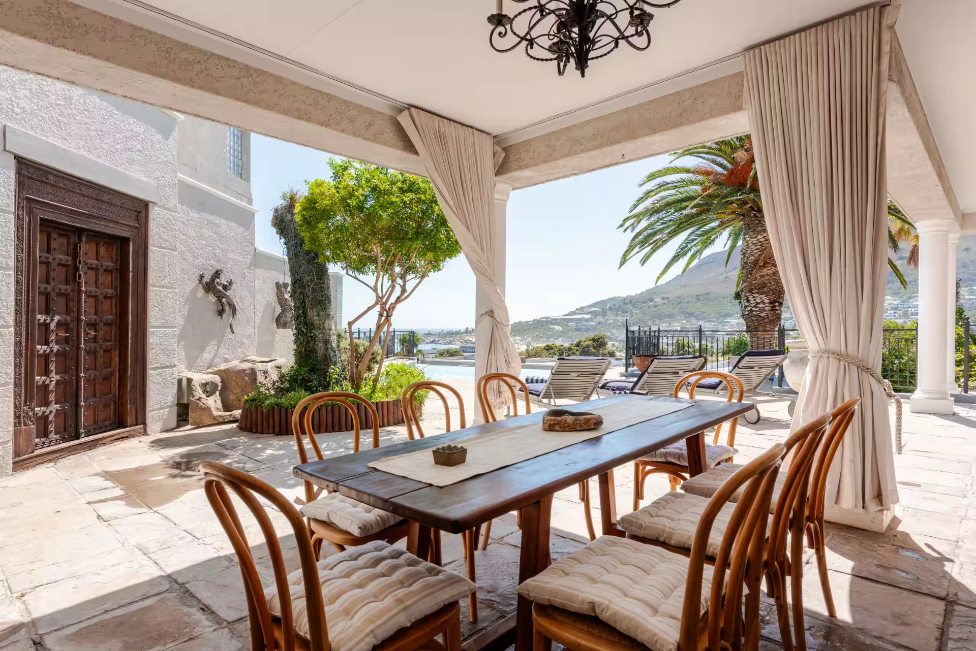 Covered terrace dining table at Feeling Azure with the pool and ocean beyond